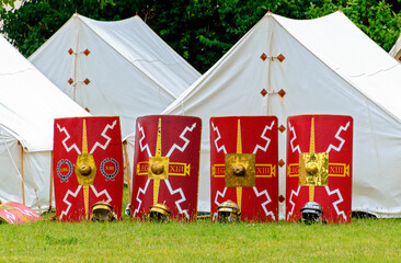 camp of the 13th legion with white tents, shields and helmets at an event in the roman town of carnu
