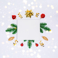 Wall Mural - christmas postcard with white paper blank, golden decorations, fir tree branches and sparkles on lig