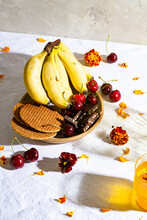 Bananas, Cherries, Crackers And Chocolate Bars On Plate