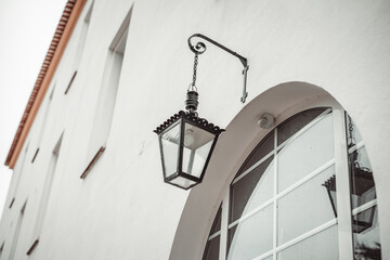 Wall Mural - a small electric lamp with a lamp hanging over the entrance to the house