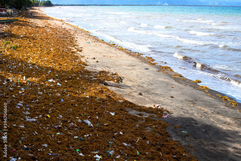 Sea water with waves, seaweed and garbage. Aquatic trash on tropical