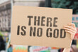 © AndriiKoval - The phrase ' There is no god ' on a banner in men's hand with blurred background. Religion. Belief. Believe. Culture. Atheism. Disagree. Untruth. Refuse