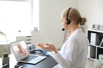 Wall Mural - Female doctor giving a consultation online in clinic