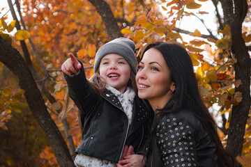 happy mother and child daughter walk in the autumn