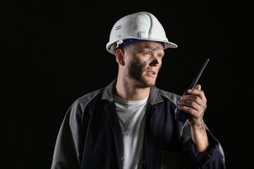 Wall Mural - Miner man with two-way radio on dark background