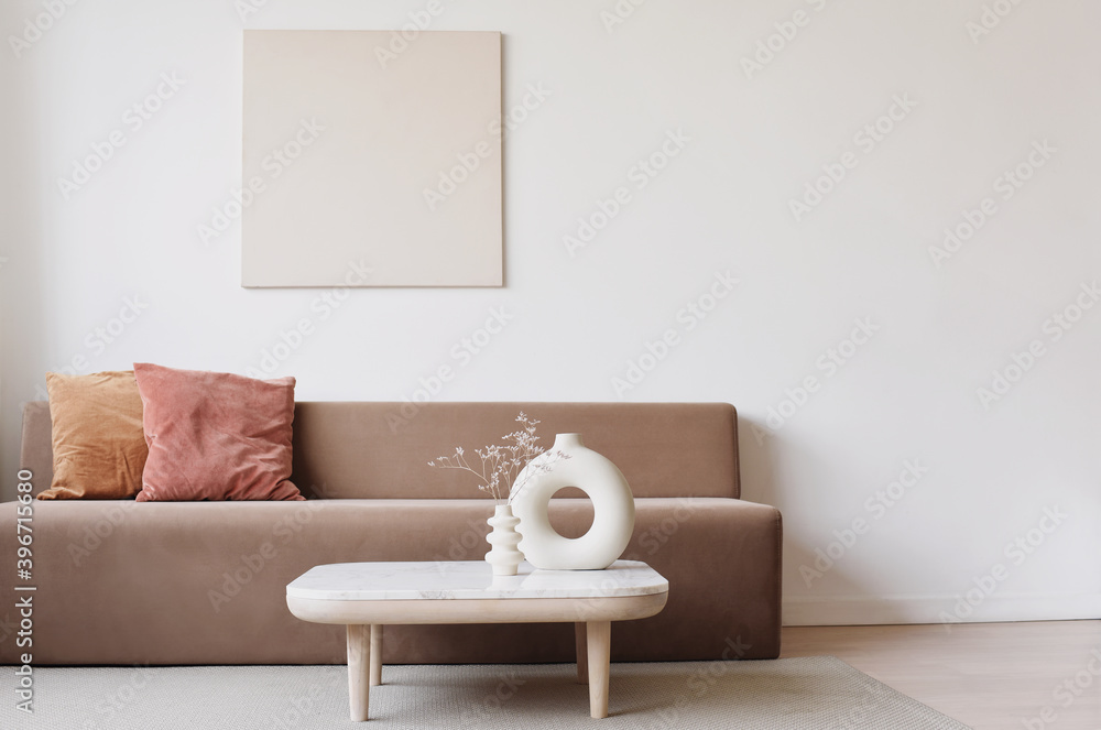 Blank picture frame mockup on white wall. White living room design. View of modern scandinavian style interior with sofa. Home staging and minimalism concept - obrazy, fototapety, plakaty 