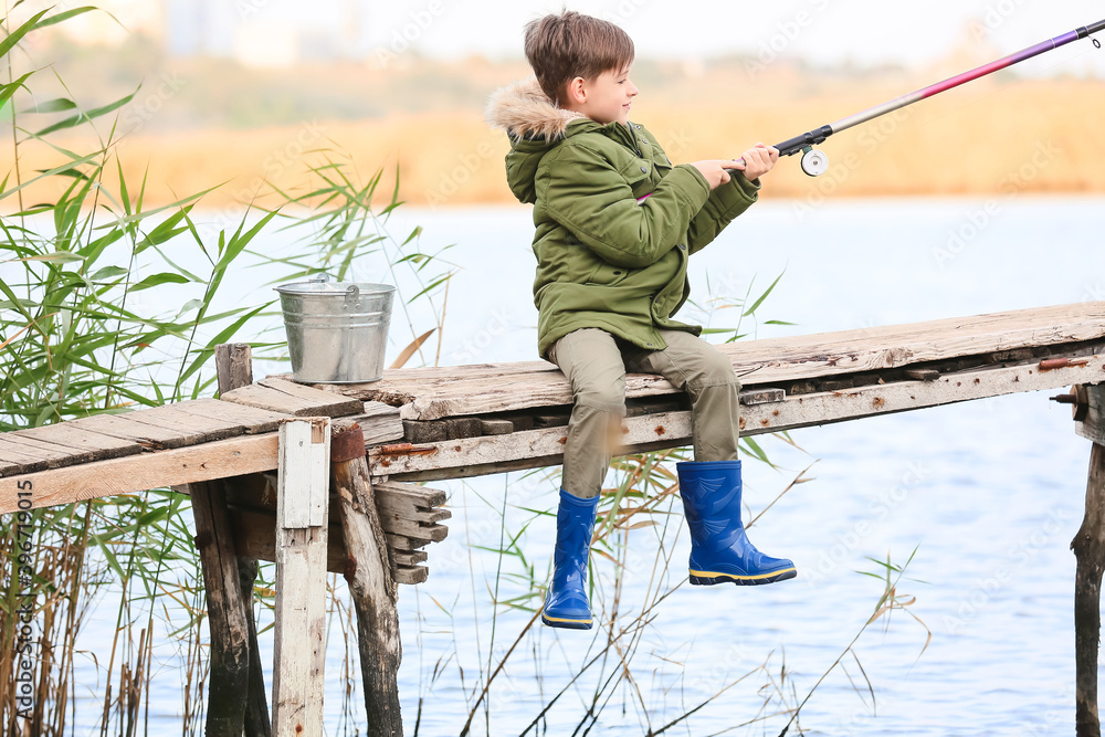 Little boy fishing on river