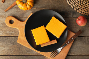 Plate with pieces of tasty pumpkin pie on table