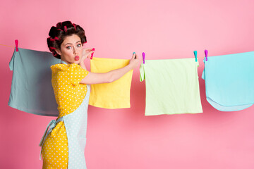 Poster - Profile side view portrait of glamorous flirty housemaid hanging fresh textile on rope pout lips isolated on pink pastel color background