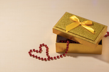 a heart of red beads and a yellow gift cork on the table