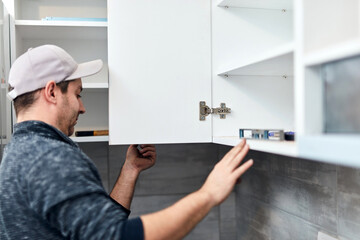 Wall Mural - Handyman worker assembling furniture and fixing it.