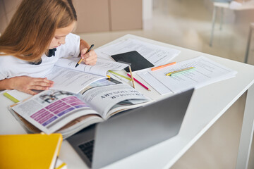 Wall Mural - Concentrated student tracing her reading progress with an eco-pen