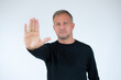 © Danko - Handsome young man white wall with open hand doing stop sign with serious and confident expression, defense gesture.