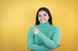© Irene - Young caucasian woman over isolated yellow background smiling and pointing with hand and finger to the side