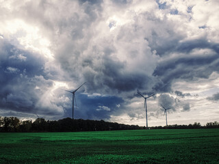 wind turbine in the field with impressive clouds