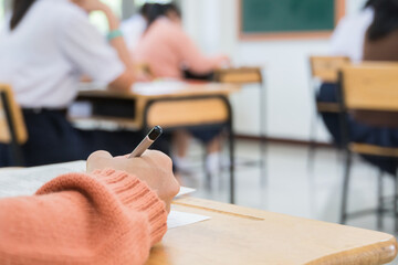 Wall Mural - hand student taking exam or test in exercise taking fill in exam carbon paper computer sheet with pe