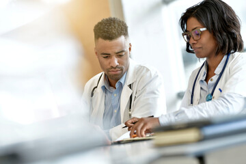 Wall Mural - Young doctors working on laptop at the hospital