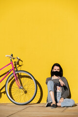 Wall Mural - young girl wearing mask sitting with vintage bike