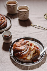 Wall Mural - Cinnamon swirl brioche or Cinnamon roll bun and cups of cocoa on greige linen tablecloth. Homemade baked swedish cinnamon roll. Kanelbullar. Cozy winter breakfast