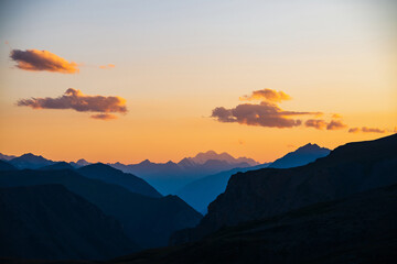 Wall Mural - colorful dawn landscape with beautiful mountains silhouettes and golden gradient sky with lilac clou