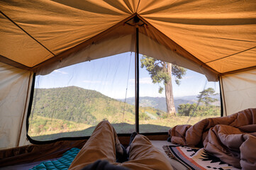 Wall Mural - man relaxing in a tent on hill with blue sky