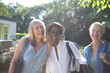 © Tom Merton/Caia Image - Portrait playful senior women friends in sunny summer garden