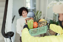 Grateful Woman Receiving Grocery Delivery From Courier At Home