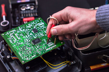 Technician repair electronic circuit board with soldering iron and tin wire.  Repair of electronic devices, tin soldering parts. Electronic laboratory