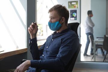 Wall Mural - Caucasian man wearing mask in an office