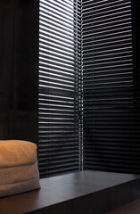 Poster - Wood blinds black color closeup on the window in the interior. Wooden slats 50mm wide, black tapes. Venetian blinds closed in the room.