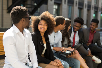 Wall Mural - team of beautiful african people on a bench in summer