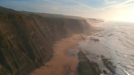 Sticker - Aerial view of waves on a beautiful sandy ocean beach and cliff.