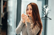 © Alina - Happy smiling asian woman tries new perfume fragrances in perfume shop