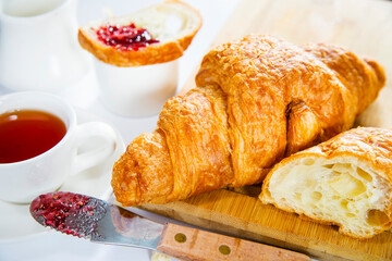 croissant with berry jam on a white table