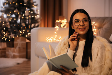 Poster - Young woman with book at home, space for text. Christmas celebration