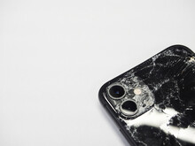 Los Angeles, California, USA - 01 December 2020: (Top View) The Back Of The Black IPhone 11 Has Broken Glass On White Background. Modern Smartphone With Damaged Back Glass.