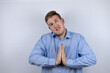 © Irene - Business young man wearing a casual shirt over white background begging and praying with hands together with hope expression on face very emotional and worried