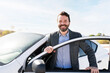 © AntonioDiaz - Latin man making eye contact while smiling and getting off a vehicle