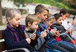 © JackF - Group of children posing at urban street with mobile devices in autumn