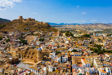 Wall Mural - Aerial view of Spanish city of Lorca overlooking Collegiate church of St. Patrick and ancient castle on hilltop on sunny autumn day