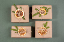 Christmas And New Year Gifts. Craft Paper Boxes Decorated With Dried Oranges, Spruce Branches And Twine . Concept Zero Waste, Eco Friendly Merry Christmas