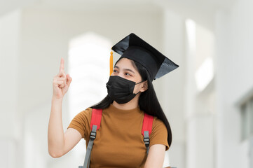 Wall Mural - Female college students, university graduates, wear black hats, yellow tassels and wear masks during the epidemic.