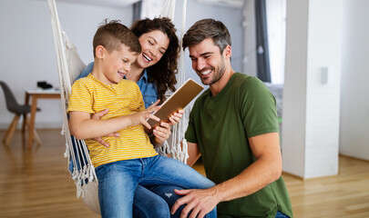 Happy family spending time at home and looking something fanny on tablet.