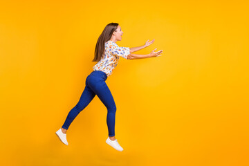 Sticker - Photo portrait full body profile view of woman catching something with hands jumping up isolated on vivid yellow colored background