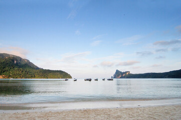 Wall Mural - A scenic view of small bay at Phi Phi Island with a few of  traditional long tail boats in distance.