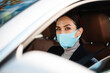 © Drobot Dean - Beautiful confident pleased businesswoman in face mask driving car