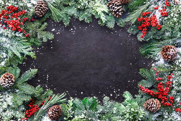 Wall Mural - christmas and new year background with fir branches and snowfall on dark stony board