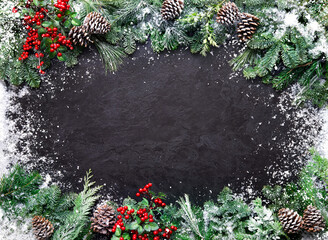 Wall Mural - christmas and new year background with fir branches and snowfall on dark stony board