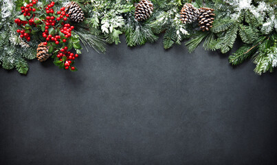 Wall Mural - christmas and new year background with fir branches and snowfall on dark stony board