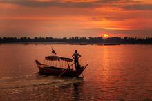 DOLPHIN WATCHING, MEKONG RIVER, KRATIE PROVINCE, CAMBODIA - 31 January 2012: Local Dolphin Watch Boat Opperator Watches Beautiful Sunset At End Of His Day.